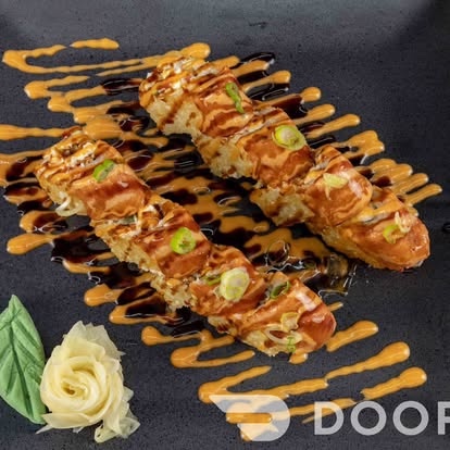 Baked sushi roll drizzled with two sauces